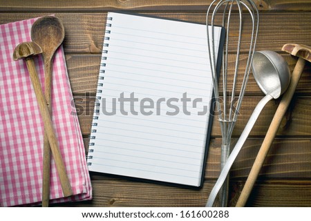 Top View Of Recipe Book With Kitchenware On Wooden Table