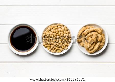 Soy Sauce, Soybeans And Soy Meat In Bowls On Wooden Table