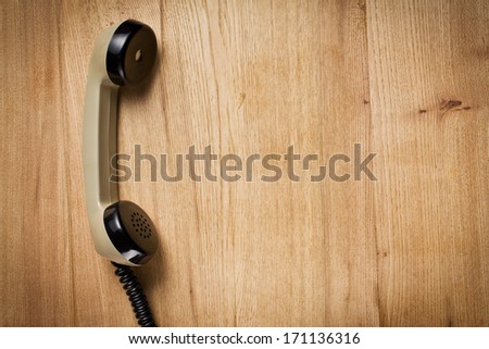 top view of old telephone handset on wooden table