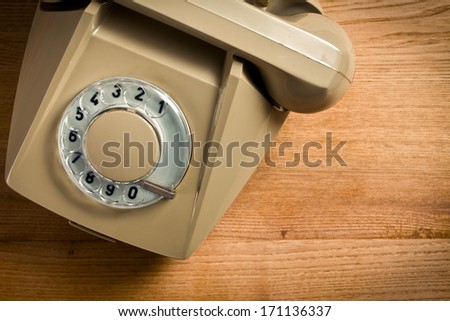 top view of old beige telephone on wooden table