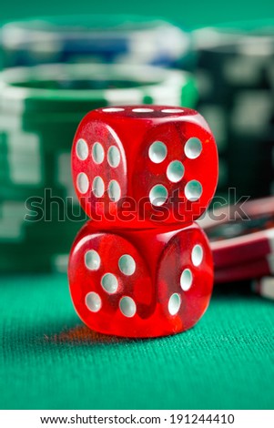 the red casino dice and casino chips on green table