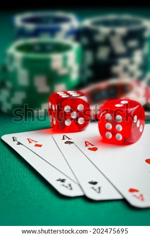 the red casino dice and poker cards on green table