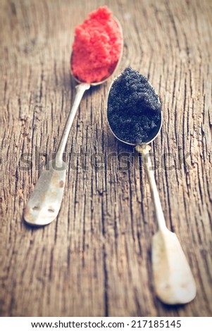 black and red caviar in spoon on wooden table