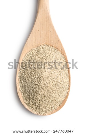 dry yeast in wooden spoon on white background