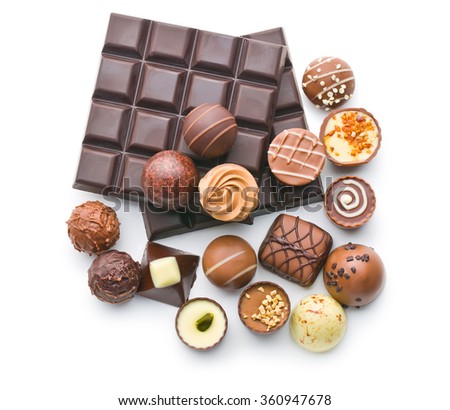 various chocolate pralines and chocolate bar on white background