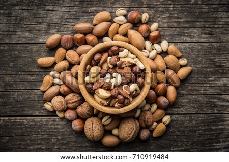 Different types of nuts. Hazelnuts, walnuts, almonds, brazil nuts and pistachio nuts on old wooden table.