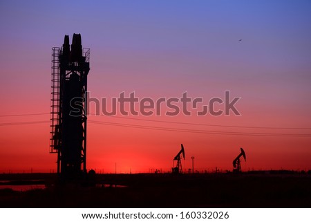 Sunset tower of the pumping unit work in the oil field