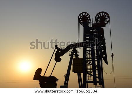 A tall tower pumping unit under the setting sun