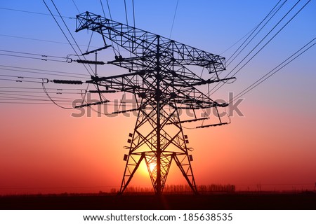 The pylon of an isolated in the fields under the setting sun  The pylon of an isolated in the fields under the setting sun