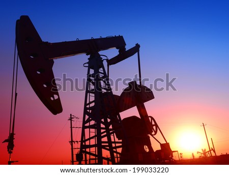 Oil field in a pumping unit is operations under the setting sun