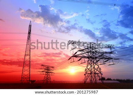The setting sun shapes under high voltage towers