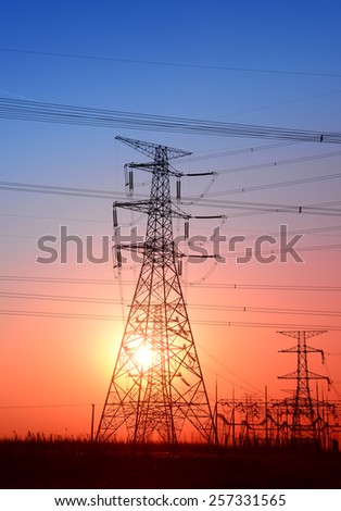 Towering high voltage power tower in the sunset