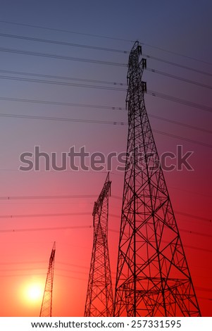 Towering high voltage power tower in the sunset