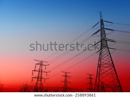 Towering high voltage towers and power site under the setting sun