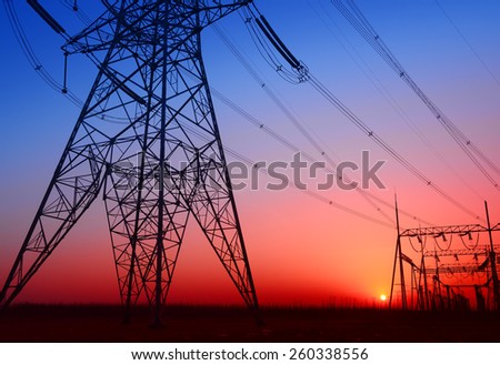 Towering high voltage towers and power site under the setting sun