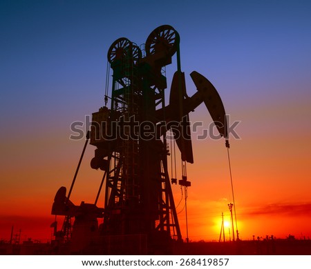 Several are operation of pumping unit under the setting sun, close-up