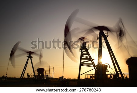 The setting sun is operation of the pumping unit in oil field