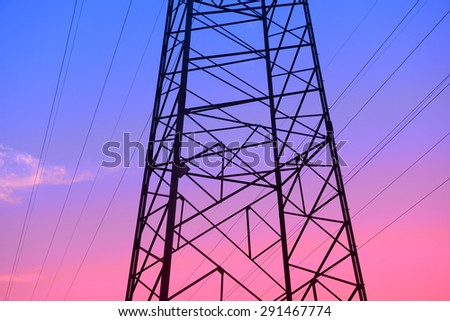 Isolation of high voltage towers under the setting sun, close-up