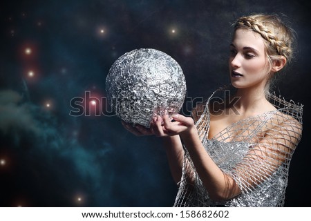 Woman holding a silver bullet against the starry sky