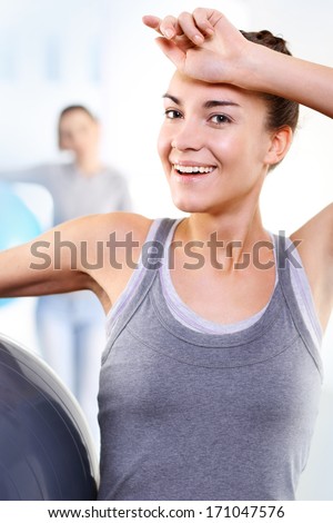 A Woman at the gym wipes the sweat from his forehead comprehensive training  .Athletic woman in the gym