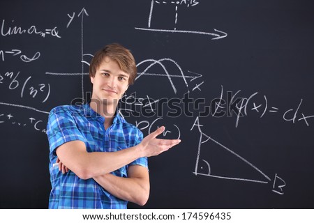 Portrait of a student at the blackboard background with patterns. Mathematics, physics, chemistry-student at the blackboard