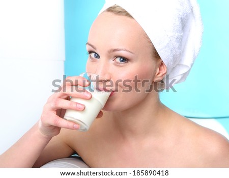 Milk diet - healthy diet  .Portrait of a young woman sitting on the sofa with a glass of milk .
