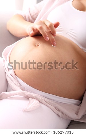 Beautiful pregnancy belly .A pregnant woman rubs lotion on big pregnancy belly