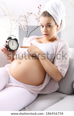 It\'s time - Fear of childbirth. Pregnant woman shows to watch, afraid of the approaching date of birth
