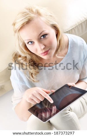 Woman with tablet touch . Figure of a young, beautiful blonde with a digital tablet, the woman touches the screen,