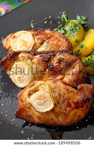 Grilled chicken fillet. Serving grilled poultry meat served on white ceramic plate