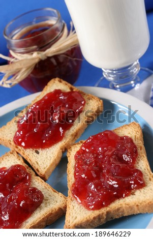 Toast with jam fruit  Homemade breakfast, toast with jam, a glass of milk and a jar of jam