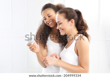 Happy women analyzes the composition of the cream. Two women learn to read the inscriptions on the jar of cream.