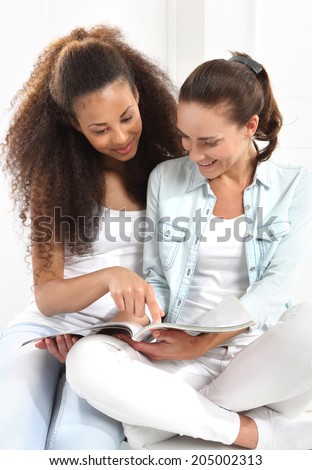 Happy women learn to read a book.  Two happy women reading a book.