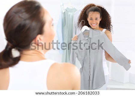 Boutique, women shopping .Two women shopping in boutique clothing, mulatto and Caucasian