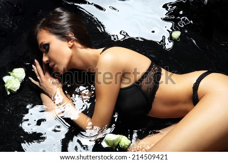 Bath- sensual beautiful woman in water  .Sensual woman bathes in the black water dressed in sexy underwear.
