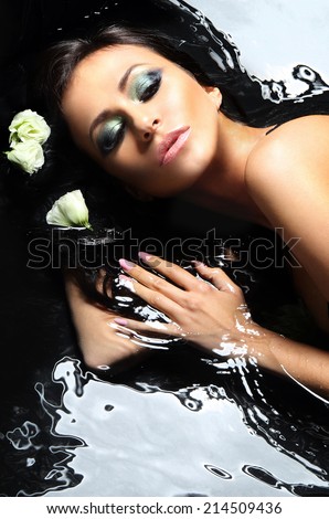Portrait of beautiful the Spanish .Sensual woman bathes in the black water dressed in sexy underwear.