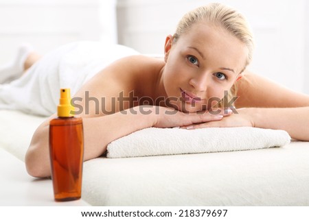 Therapeutic massage, heals the pain and relaxes .Woman on the back massage.Attractive blonde woman in the office spa, relaxes August waiting for a cosmetic procedure.