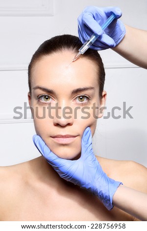 Horizontal forehead wrinkles, filler injection.Portrait of a white woman during surgery filling facial wrinkles