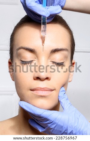 Wrinkle reduction, the lion\'s wrinkle injection Botox.Portrait of a white woman during surgery filling facial wrinkles
