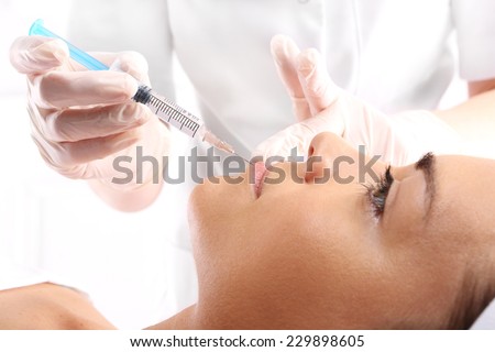 Enlarging the lips, lip correction .Portrait of a white woman during surgery filling facial wrinkles, Cosmetic is injected into facial skin cosmetics