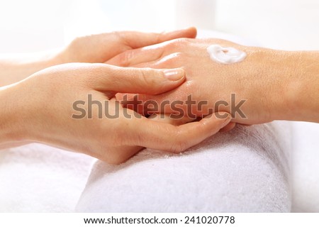 Hand massage, the woman to a beautician, hand lotion.Treatment hand and nail care, the woman to a beautician for a manicure.