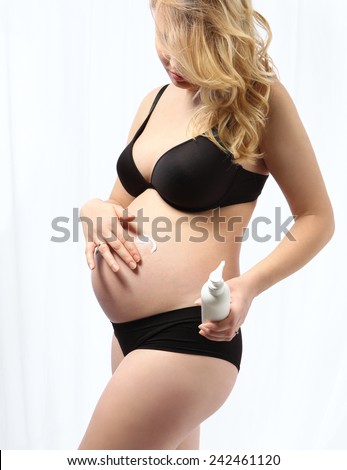 Belly pregnancy care.  Pregnant woman belly lubricates balm for stretch marks