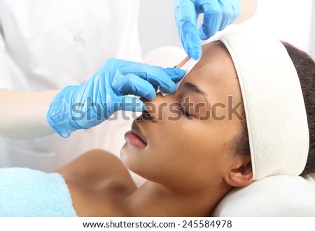 Styling eyebrows in the beauty salon . Hair removal, eyebrow regulation wax in the beauty salon