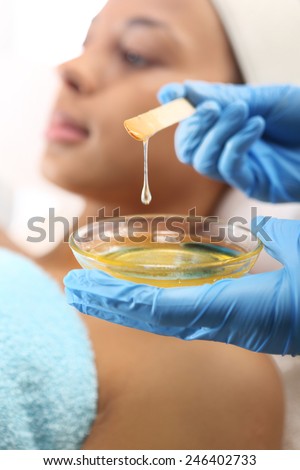 Hot wax hair removal. Woman in a beauty salon waxing during surgery