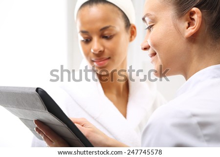 Cosmetic consulting, direct sale. Two women in wellness salon dressed in white robes