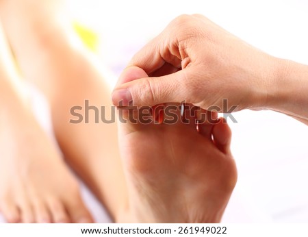 Foot massage. Masseuse massaging woman\'s foot.