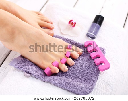 Purple pedicure, groomed female foot. Foot care treatment and nail, the woman at the beautician for pedicure.