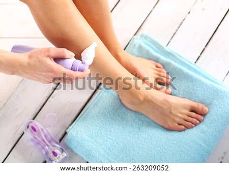 Hygiene legs, the woman applied foam for hair removal.Female legs goals manual razor