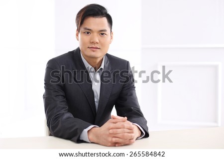 Tax advisor, law and money. Handsome man in business suit sitting at his desk in his office.
