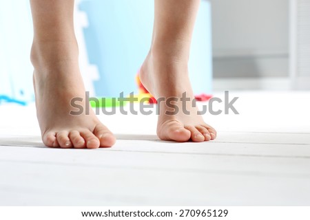 Children\'s bare feet.\
Child\'s bare feet on the wooden floor